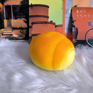 Detailed macro shot of a large slow rebound orange bread squishy toy on soft white fur