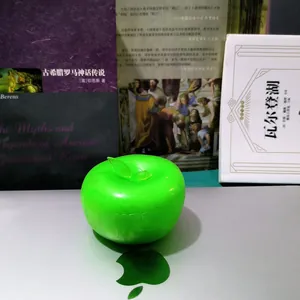 Close-up of a green slushy apple squishy fidget toy on a silver surface