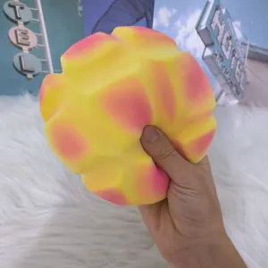 Λεπτομέρεια ενός μαλακού ροζ-κίτρινου squishy ψωμιού ανανά με αργή επαναφορά.
