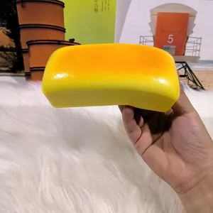 Close-up of a long yellow squishy cheese bread toy being squeezed for stress relief