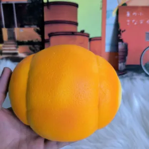 Detailed macro view of a large orange slow rebound pig bun squishy toy held in hand