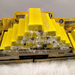 Set mit 12 Goldbarren-Squishy-Spielzeugen in Displaybox auf weißem Fell
