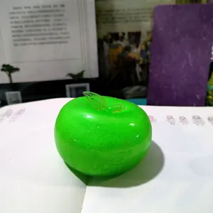 Bright green slushy apple squishy fidget toy for stress relief on a white notebook