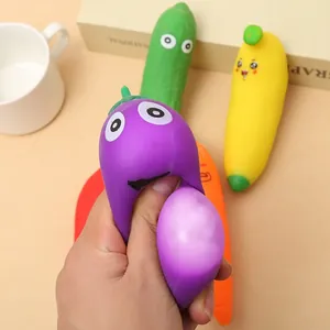 Close-up of a hand squeezing a purple eggplant toy to show the squishy TPR texture