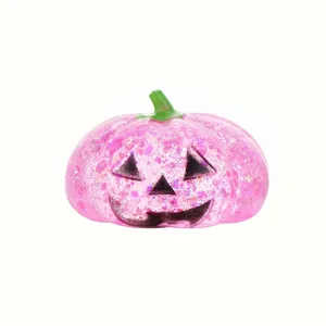 Detailed macro view of a pink glittery glow-in-the-dark Halloween pumpkin miniature figurine