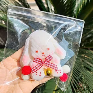 Cute white plush rabbit squeeze toy with a red gingham bow and bell for stress relief