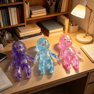Detailed view of three colorful transparent glitter squeeze dolls on a warm lit desk.