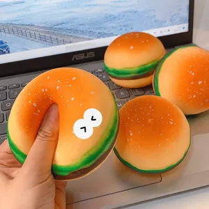 Realistic hamburger squishy toy for stress relief shown on a laptop keyboard background