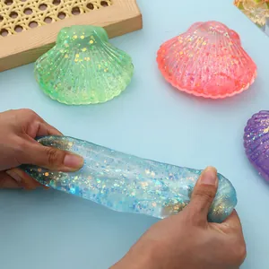 Detail shot of blue glittery seashell slime being stretched for stress relief.