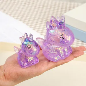 Detailansicht von glitzernden lila Einhorn-Antistress-Spielzeugen in einer Hand