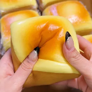 Λεπτομερής όψη μεγάλου παιχνιδιού squishy ψωμί με τυρί που δείχνει τη μαλακή υφή του όταν πιέζεται