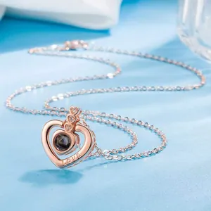 Close-up of heart projection necklace in rose gold with LOVE engraving