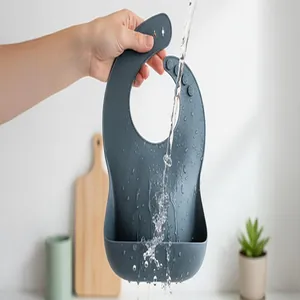 Durable waterproof silicone baby bib with 3D food catcher pocket rinsed under water