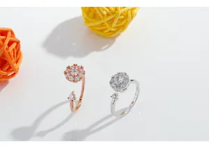 Top view of two adjustable crystal flower rings in rose gold and silver finishes