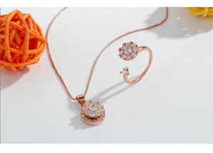 Detailed view of rotating rose gold flower necklace and adjustable ring set with crystals.