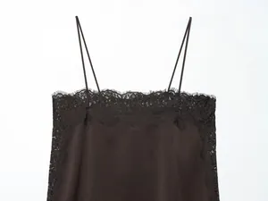 Close-up of black silk-satin camisole featuring delicate eyelash lace trim details.