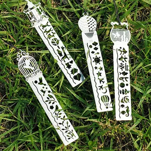 Creative set of 4 metal hollowed-out rulers and bookmarks with intricate patterns on grass