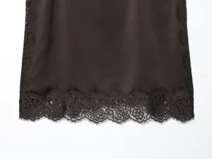 Detail of delicate black eyelash lace on a dark brown satin camisole top
