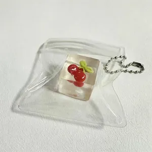 Detailed view of a realistic cherry ice cube squishy toy inside a clear plastic pouch.