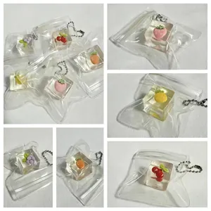 Detailed macro view of various fruit-themed transparent ice cube squishy toys with silver chains