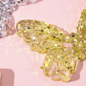 Macro detail of yellow butterfly squeeze toy with sparkling golden sequins inside