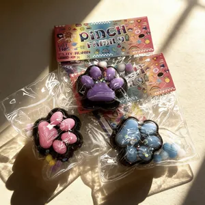 Three colorful cat paw squishy stress relief toys in purple, pink, and blue colors