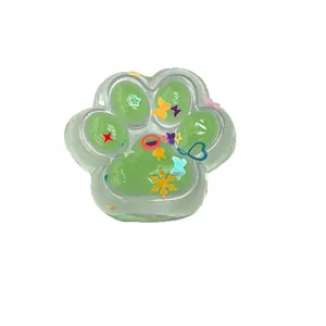 Green translucent cat paw-shaped squeeze toy for stress relief with colorful interior charms