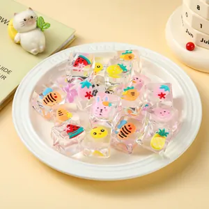 Macro detail of transparent squishy toy cubes with cute fruit and animal patterns on a plate.