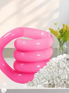 Dettaglio del giocattolo fidget a spirale rosa con granuli di materia prima trasparente.