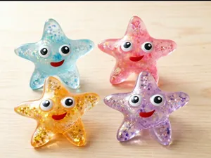 Close-up of four glittery star-shaped squeeze toys in blue, pink, orange, and purple