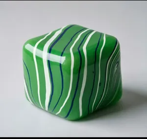 Detailed view of green flow-patterned square squishy stress relief toy with wavy stripes.