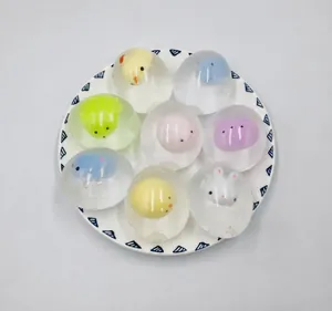 Vista dettagliata di varie palline antistress trasparenti a tema animale su un piatto.