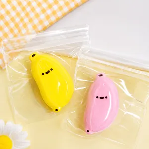 Vue détaillée des jouets anti-stress en forme de banane jaune et rose dans des sacs transparents