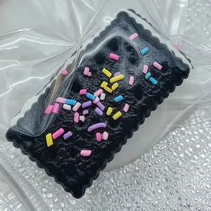 Detailansicht eines schwarzen Keks-Squishys mit bunten Streuseln und weicher Textur