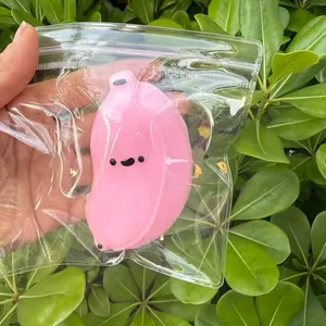 Détail du jouet squishy banane rose dans un emballage transparent sur fond de feuilles