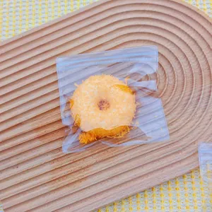 Macro view of a fried donut squishy toy with realistic breadcrumb texture in a poly bag.