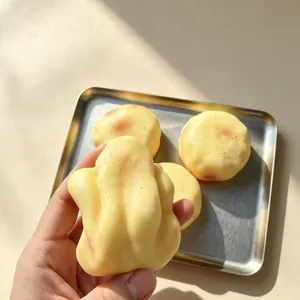 Nahaufnahme einer Hand, die ein realistisches Kartoffel-Squishy-Spielzeug zum Stressabbau drückt