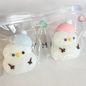 Close-up of two cute Christmas snowman stress relief toys in blue and pink winter hats