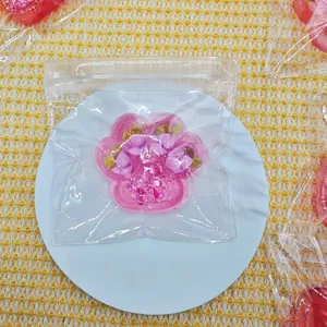 Detailed top view of a cute pink glitter cat paw squishy toy in a clear plastic package