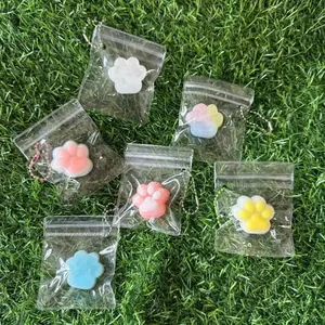Macro view of various colorful cat paw squishy stress relief toys on green grass turf.
