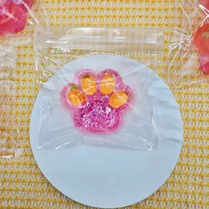 Detail view of pink cat paw squishy toy with glitter and orange embeds in a clear bag