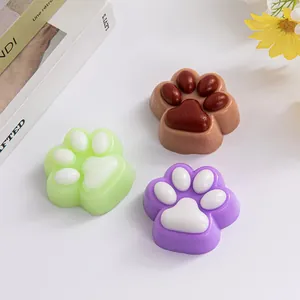Close-up view of cute cat paw squishy stress relief toys in green, purple and brown.