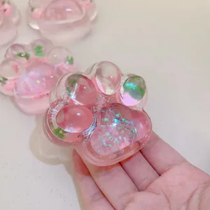Close-up of translucent pink cat paw squishy toy with glitter details