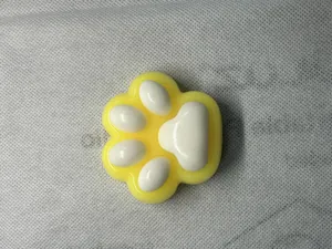 Close-up of yellow and white cat paw squishy toy with soft slow rebound texture.