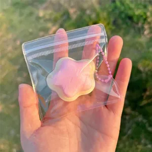 Dettaglio di un simpatico ciondolo giocattolo a stella rosa e bianco in busta