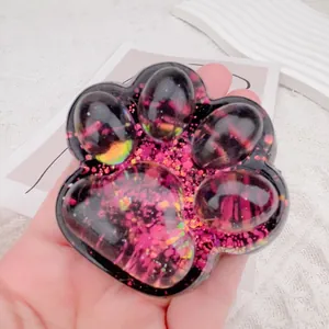 Detailed close-up of a cat paw squishy toy filled with sparkling pink sequins