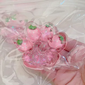 Close-up of strawberry cat paw squishy toy with glitter inside a plastic bag