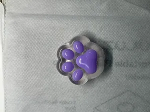 Macro detail of a cute purple cat paw squeeze toy for stress relief and soft touch.