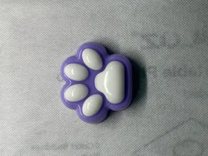Close-up of a purple and white cat paw squishy toy showing its soft texture and cute design