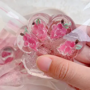Detailed close-up of a translucent pink strawberry cat paw squishy toy with glitter